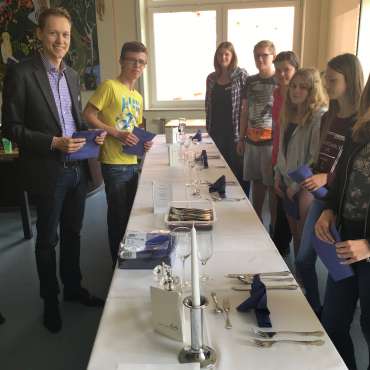Alexander Trau mit Schülern beim Eindecken einer Tafel